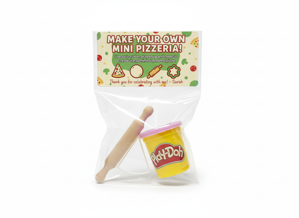 Personalised pizza party bag with make your own mini pizzeria label, full-size playdough pot, wooden roller and pizza slice cutter in a clear bag on white background